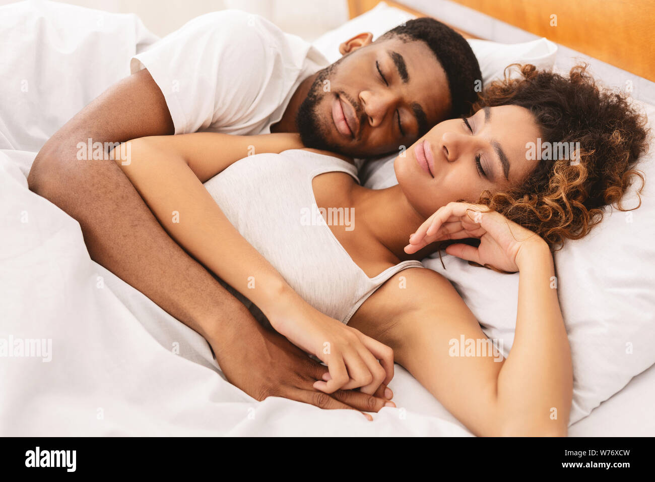 Amorosa pareja durmiendo en la cama y abrazando Fotografía de stock - Alamy