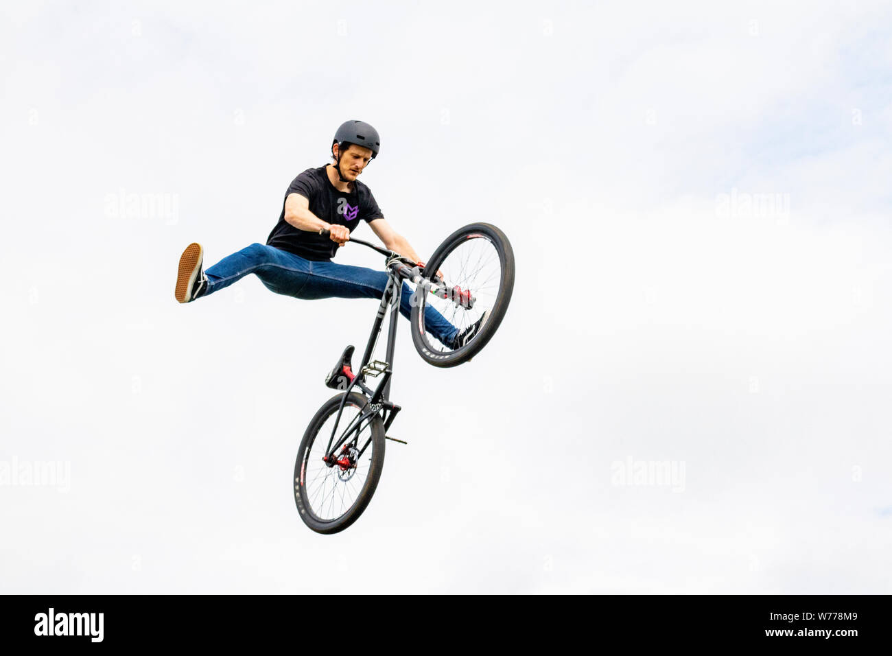 Airborne BMX Rider realizar acrobacias, dividir la Pierna Hábil maniobra en  el aire para entretener a los asistentes al Festival de Verano Fotografía  de stock - Alamy