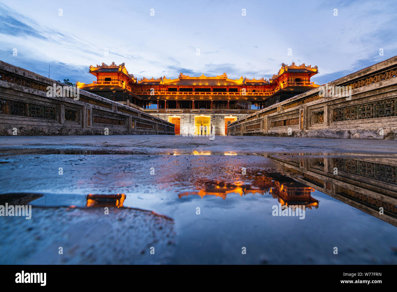 Hue, Vietnam - Junio 2019: puerta principal de la ciudad imperial prohibida púrpura al atardecer, el reflejo en el agua Foto de stock