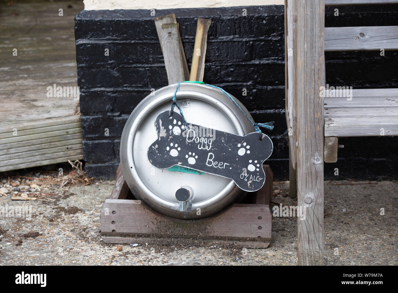 Doggy cerveza. Un signo cómico fuera de un pub que tiene un barril con agua para perros. Foto de stock