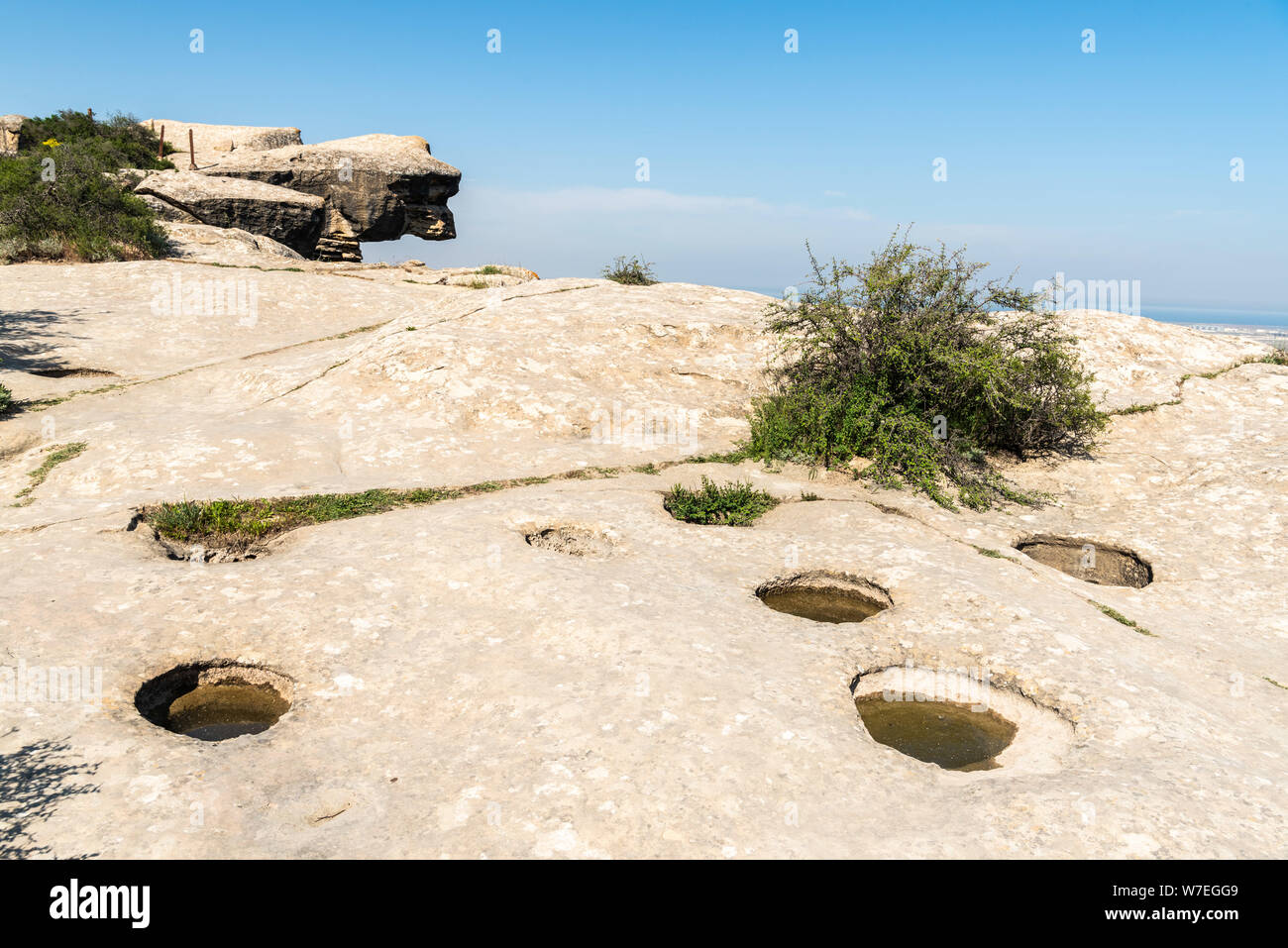 Agujeros de agua cortadas en la tierra rocosa en Gobustan, Azerbaiyán. Estos agujeros se considera el método más primitivo de recolección de aguas de lluvia y blo Foto de stock