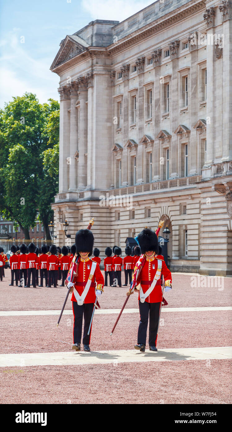 Soldados en uniformes rojos tradicionales, los miembros de la guardia de la Reina, en un desfile en la ceremonia del cambio de guardia en el Palacio de Buckingham, Londres Foto de stock