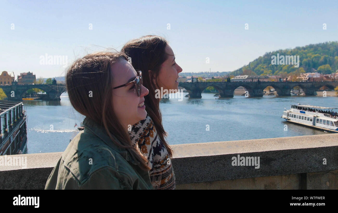 Dos jóvenes mujeres que caminan en el puente en la República Checa, Praga Foto de stock