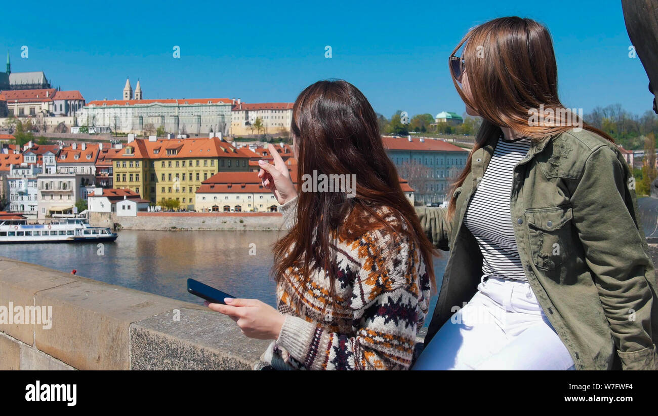 Dos jóvenes mujeres de pie en el puente y mirando a la derecha. República Checa, Praga Foto de stock