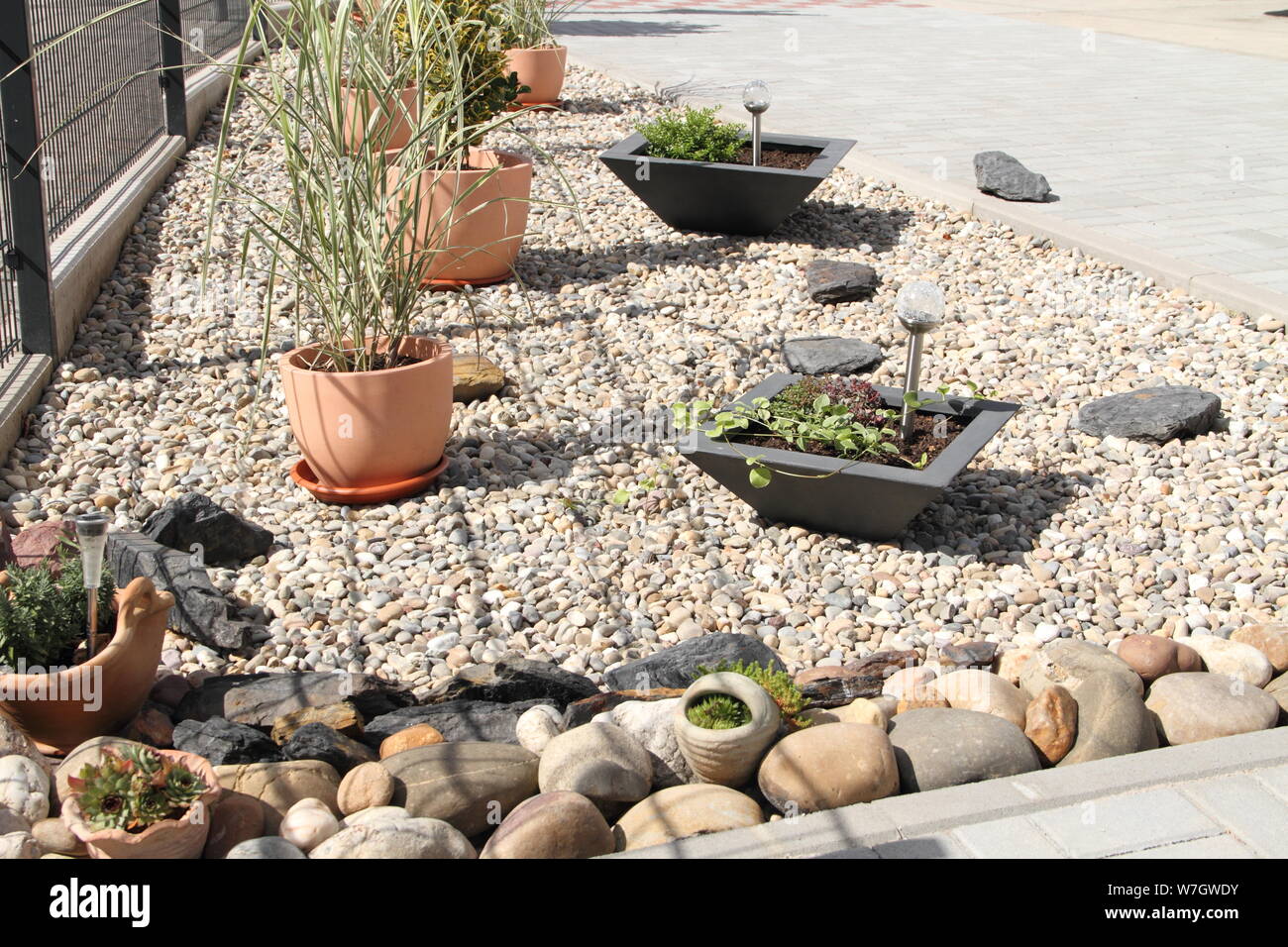 Un moderno patio delantero con piedras y planta Fotografía de stock - Alamy