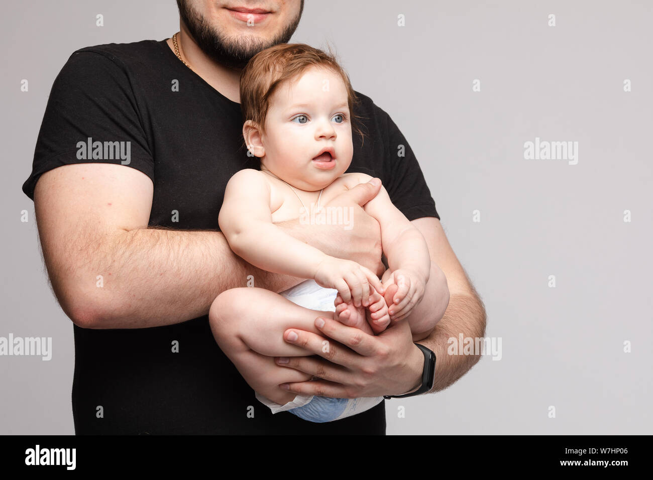 Padre mantener pequeño bebé en las manos y besarse kid Foto de stock