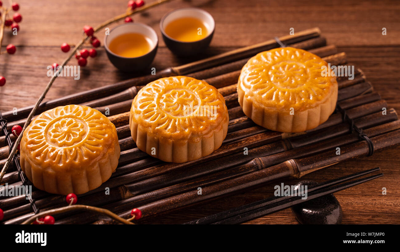 Chino tradicional pastelería Mooncake Moon Cake con tazas de té de bambú bandeja servingwarning sobre fondo de madera Mid-Autumn Festival, cerca. Foto de stock