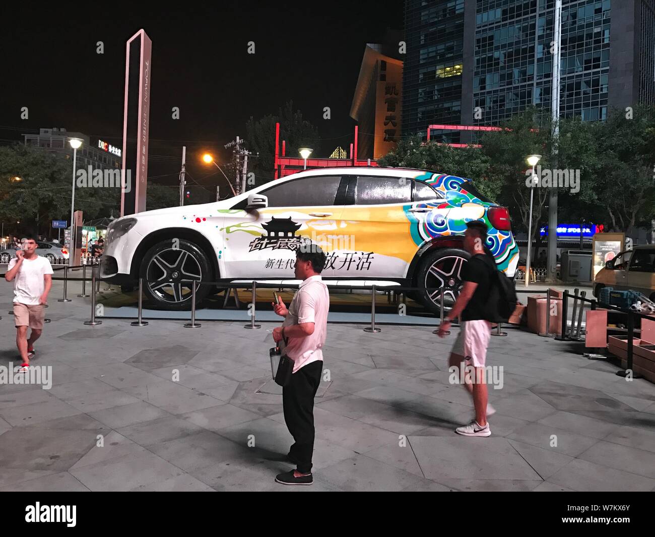 Los peatones atravesar un gigante 'Mercedes-Benz SUV GLA', de 8 metros de largo y 4 metros de altura en la exhibición en el centro comercial de Sanlitun en Beijing, China, Foto de stock