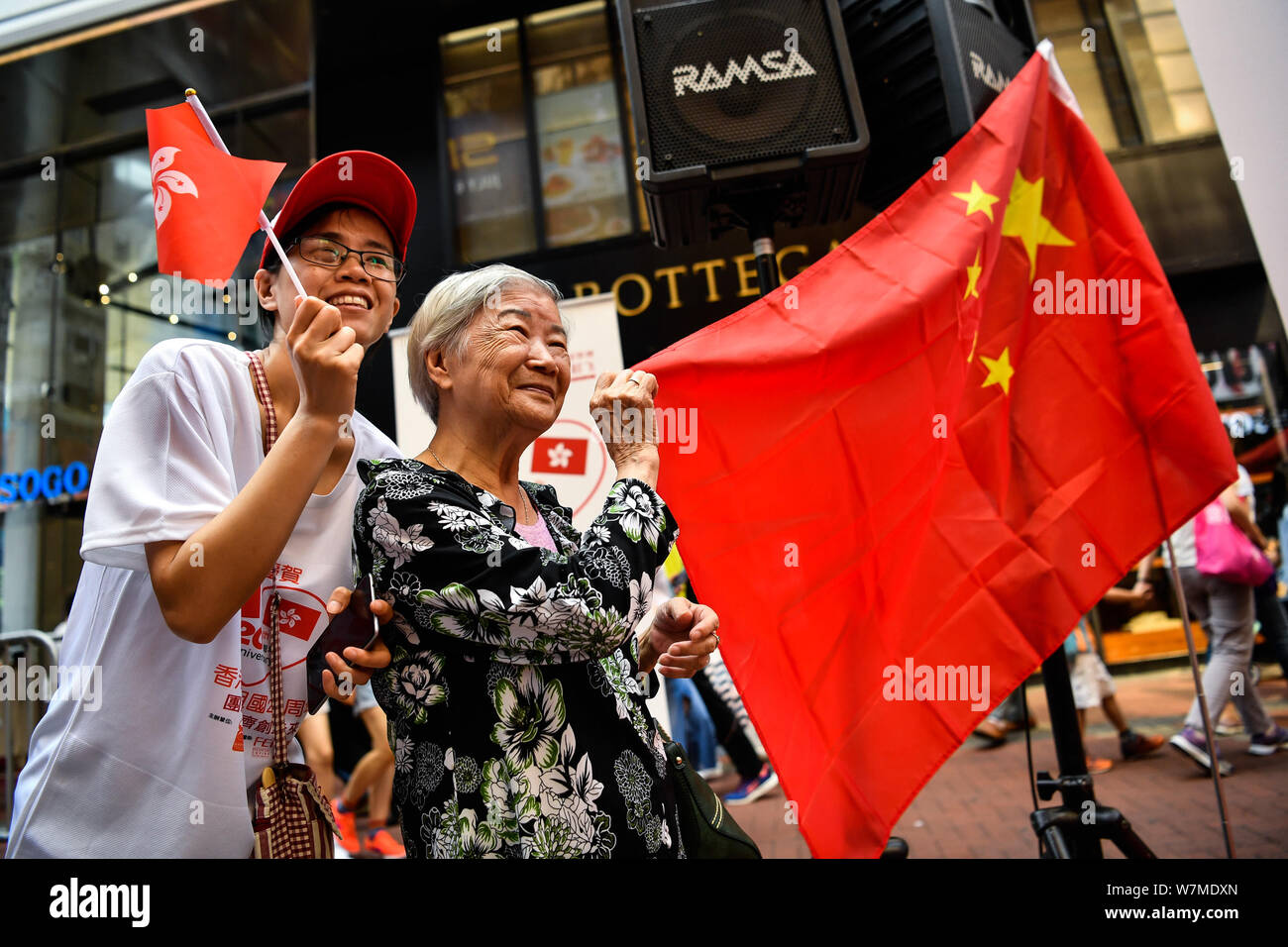 Los residentes locales agitar banderas de China y la Región Administrativa Especial de Hong Kong de la República Popular de China para conmemorar el 20º aniversario de Hong Foto de stock
