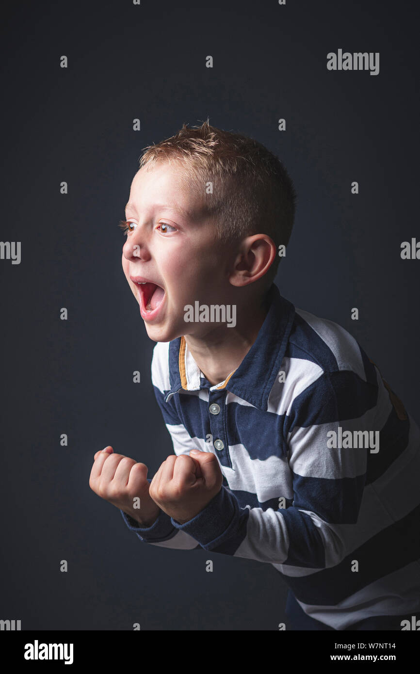 Retrato de estudio de un niño de 6 años de edad chico caucásico gritando de desesperación. Foto de stock