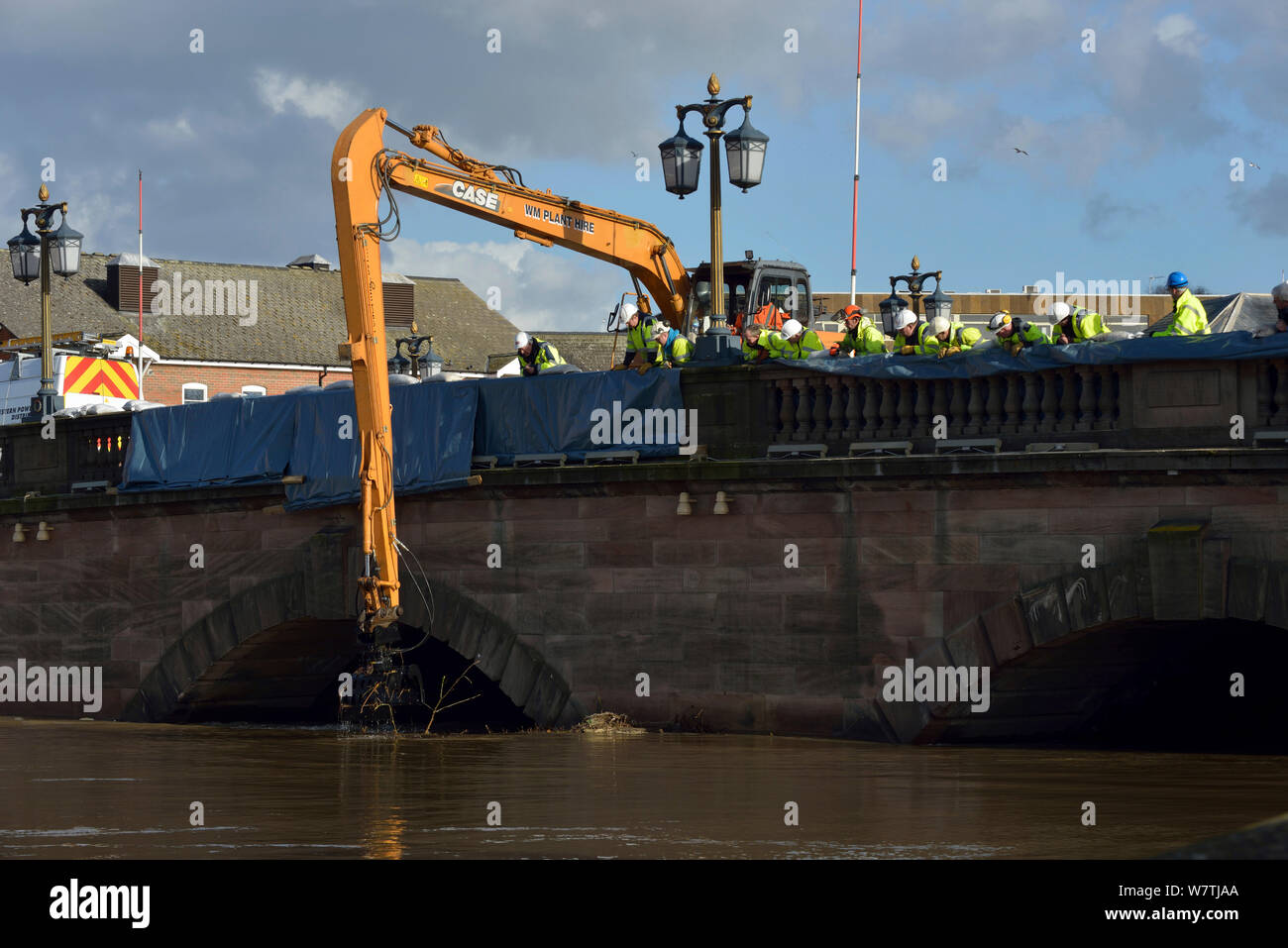 Retirar la grúa balsa desechos atrapados por Worcester puente debido a inundaciones sin precedentes, Worcestershire, Inglaterra, Reino Unido. El 16 de febrero de 2014. Foto de stock