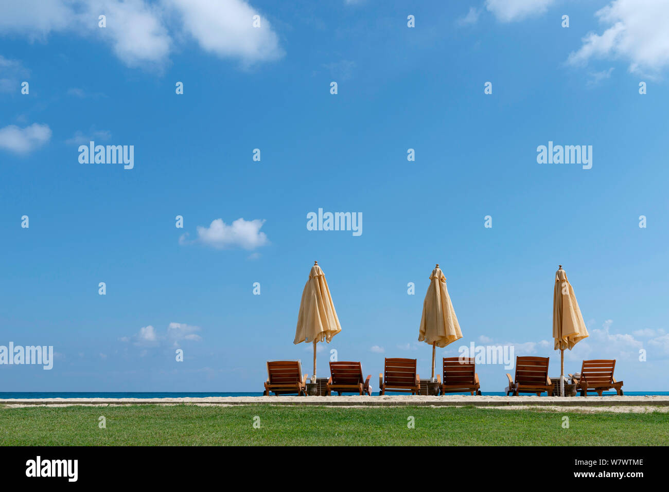 Un verano tranquilo, Tres Umbrells escena a orillas del mar, bajo la luz del sol Foto de stock