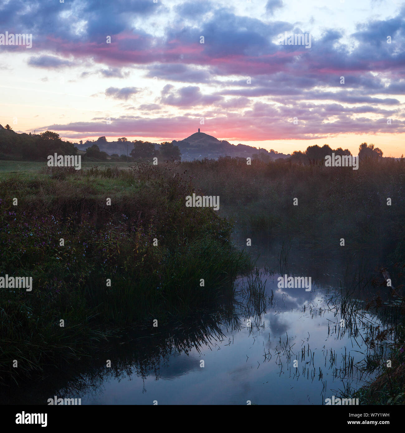 Río Brue, al amanecer con Glastonbury Tor en antecedentes, Somerset, Reino Unido, Agosto. Compuesta Digital. Foto de stock