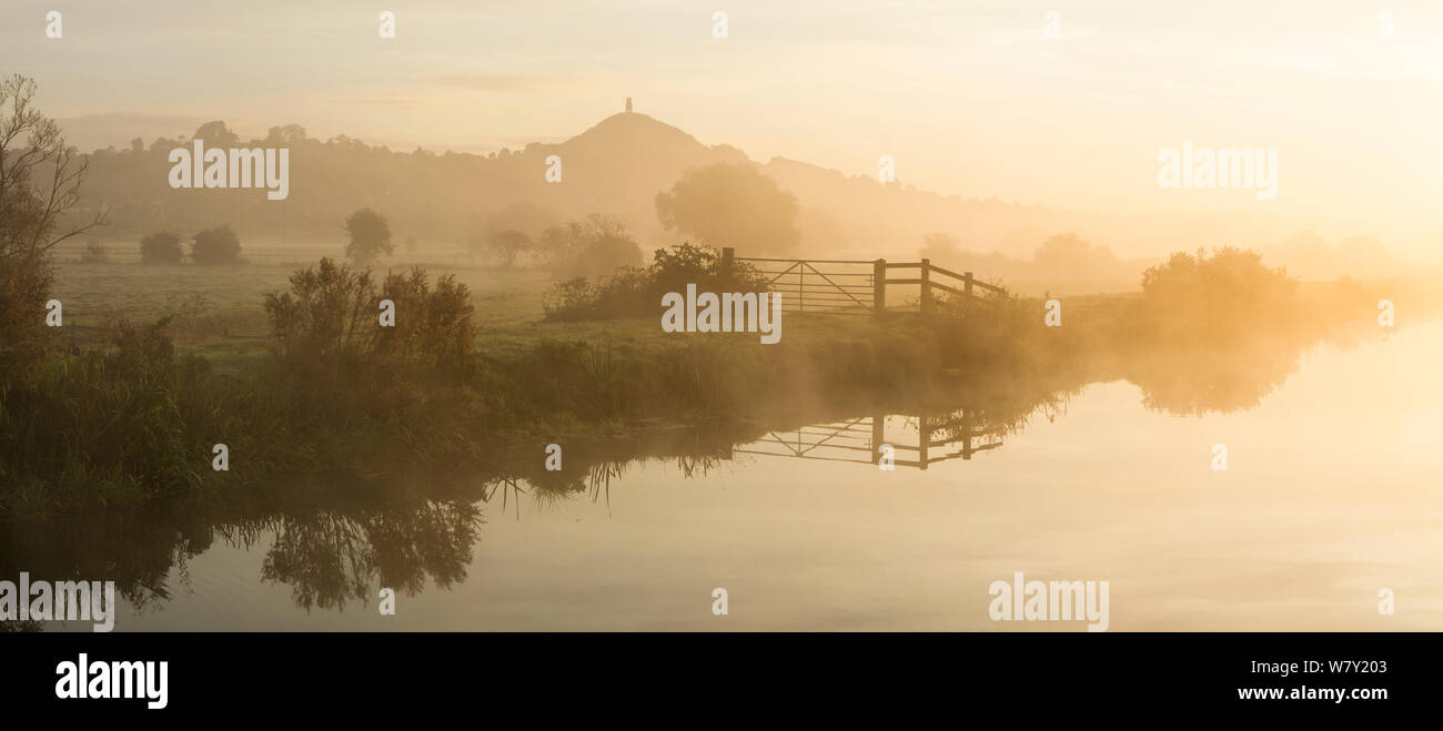 Río Brue en un brumoso amanecer con Glastonbury Tor en antecedentes, Somerset, Reino Unido, Octubre, compuesta digital. Foto de stock