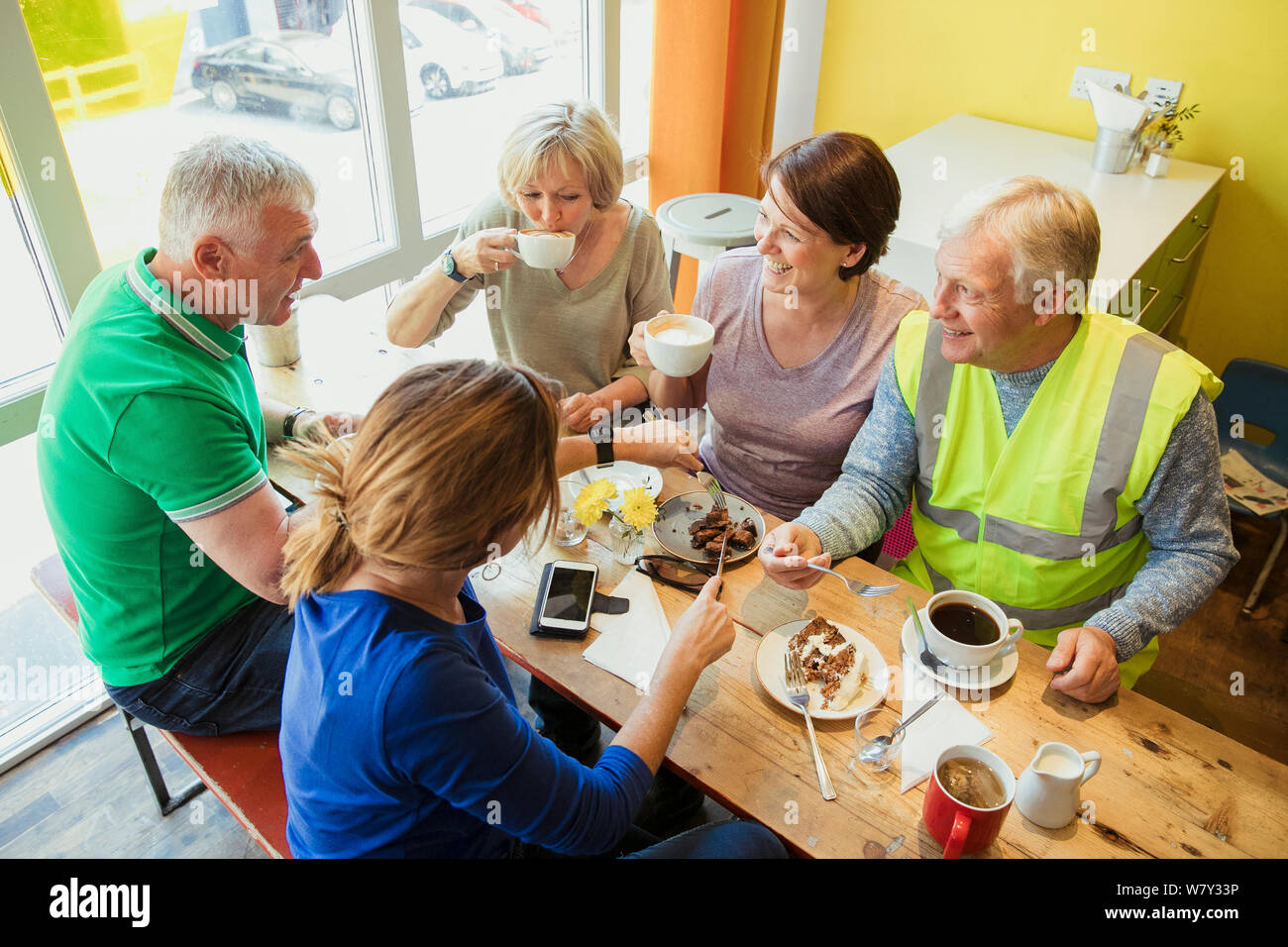 Un grupo de cinco personas, tomar un descanso de limpieza de la ciudad y con café y tarta. Foto de stock
