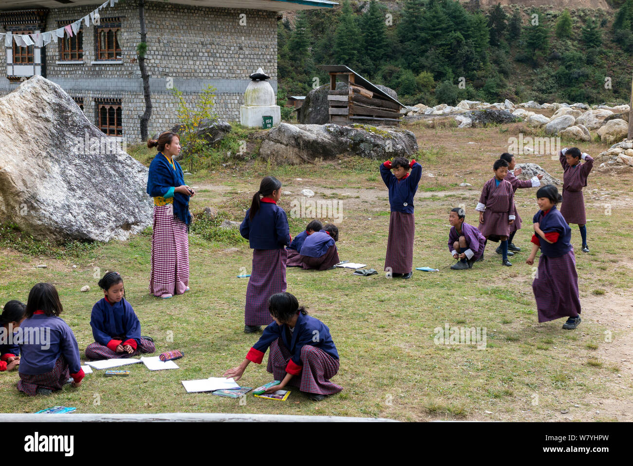 Los niños en la escuela infantil, con el maestro de pie al lado, Paro del valle del río. Bhután, octubre de 2014. Foto de stock