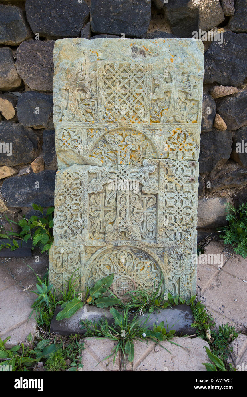 Cruz de piedra (khachkar) colocados a lo largo de la pared de la Iglesia armenia, Mayo. Foto de stock