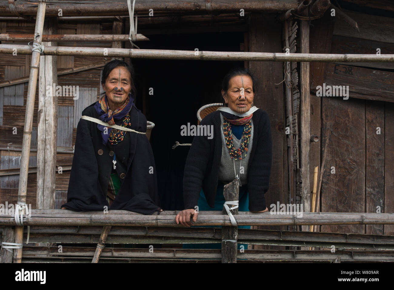 Las mujeres Apatani con tatuajes faciales y nariz tradicionales tapones / Yapin Hulo realizados para que parezcan poco atractivas para los hombres de otras tribus. Estas modificaciones faciales están ahora prohibidos. Apatani tribu, Ziro Valle, estribaciones del Himalaya, Arunachal Pradesh.En el noreste de la India, en noviembre de 2014. Foto de stock