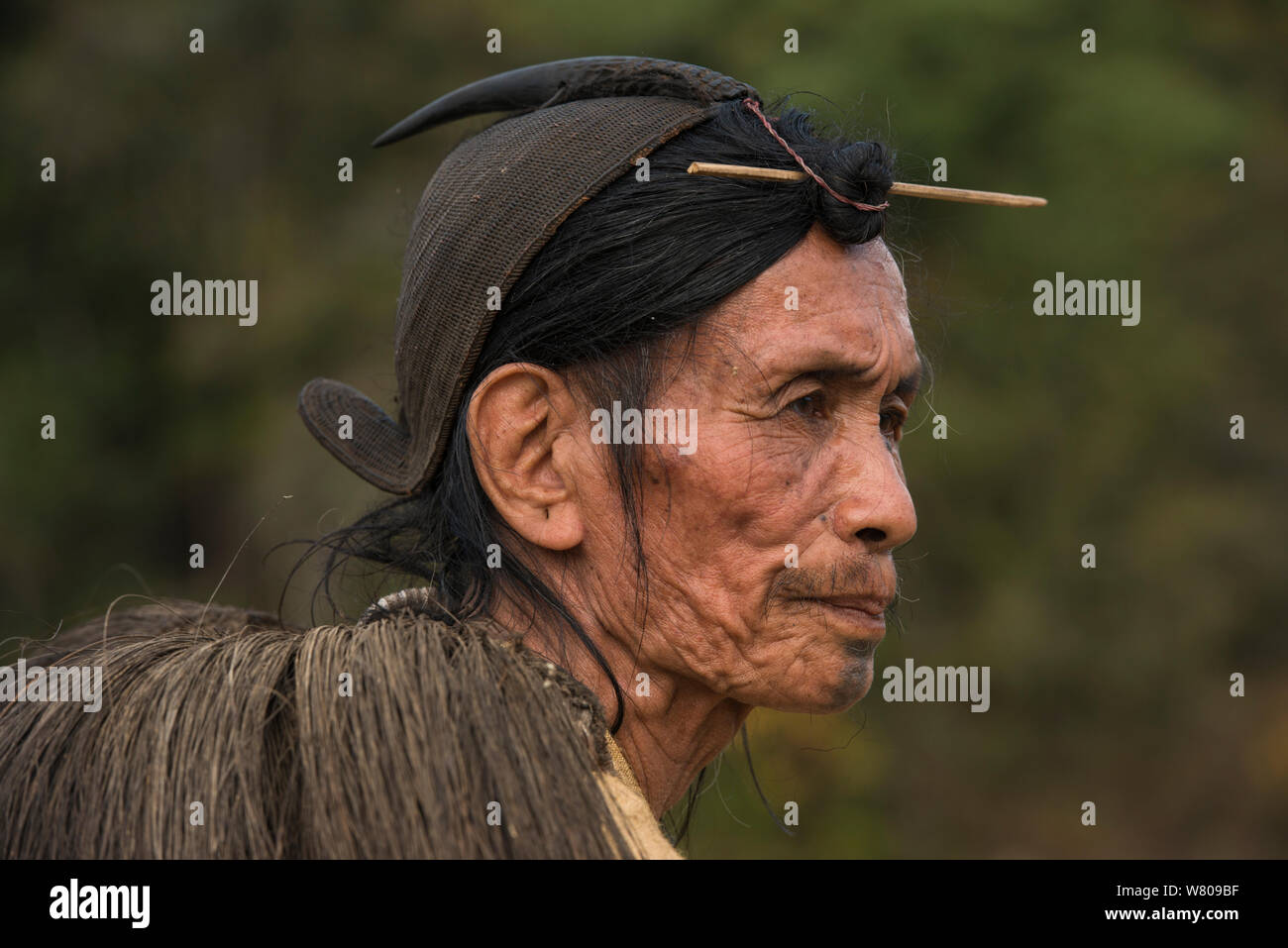Hombre con cabello Apatani tradicional nudo fijado por un pincho o Piidin Khotu Lecha y tradicional sobre el hombro y el sombrero de caña que incluye un pico hornbills. Apatani tribu, Ziro Valle, estribaciones del Himalaya, Arunachal Pradesh.En el noreste de la India, en noviembre de 2014. Foto de stock