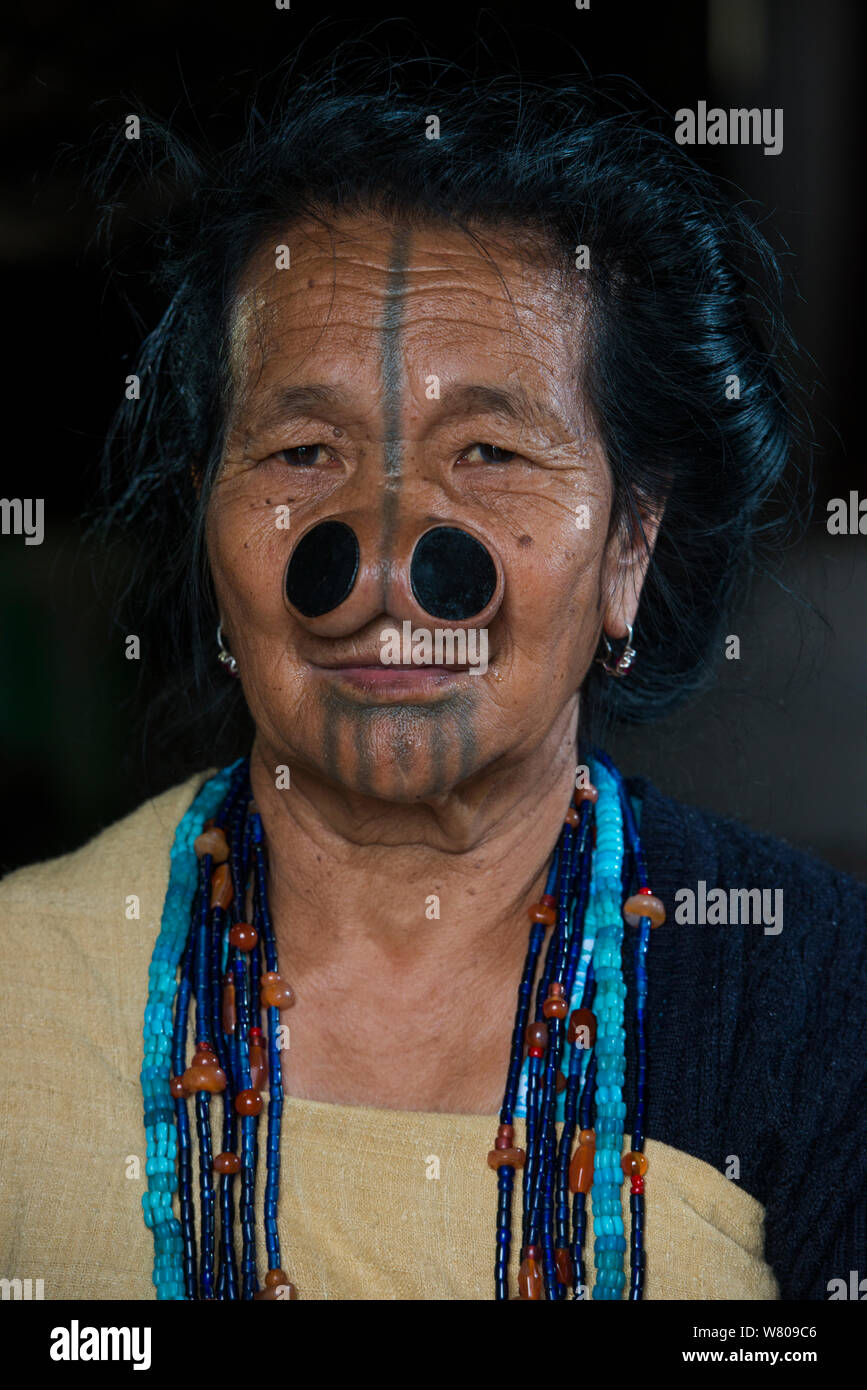 Apatani mujer con tatuajes faciales y tapones de punta de caña tradicional / Yapin Hulo realizados para que parezcan poco atractivas para los hombres de otras tribus. Estas modificaciones faciales están ahora prohibidos. Apatani tribu, Ziro Valle, estribaciones del Himalaya, Arunachal Pradesh.En el noreste de la India, en noviembre de 2014. Foto de stock