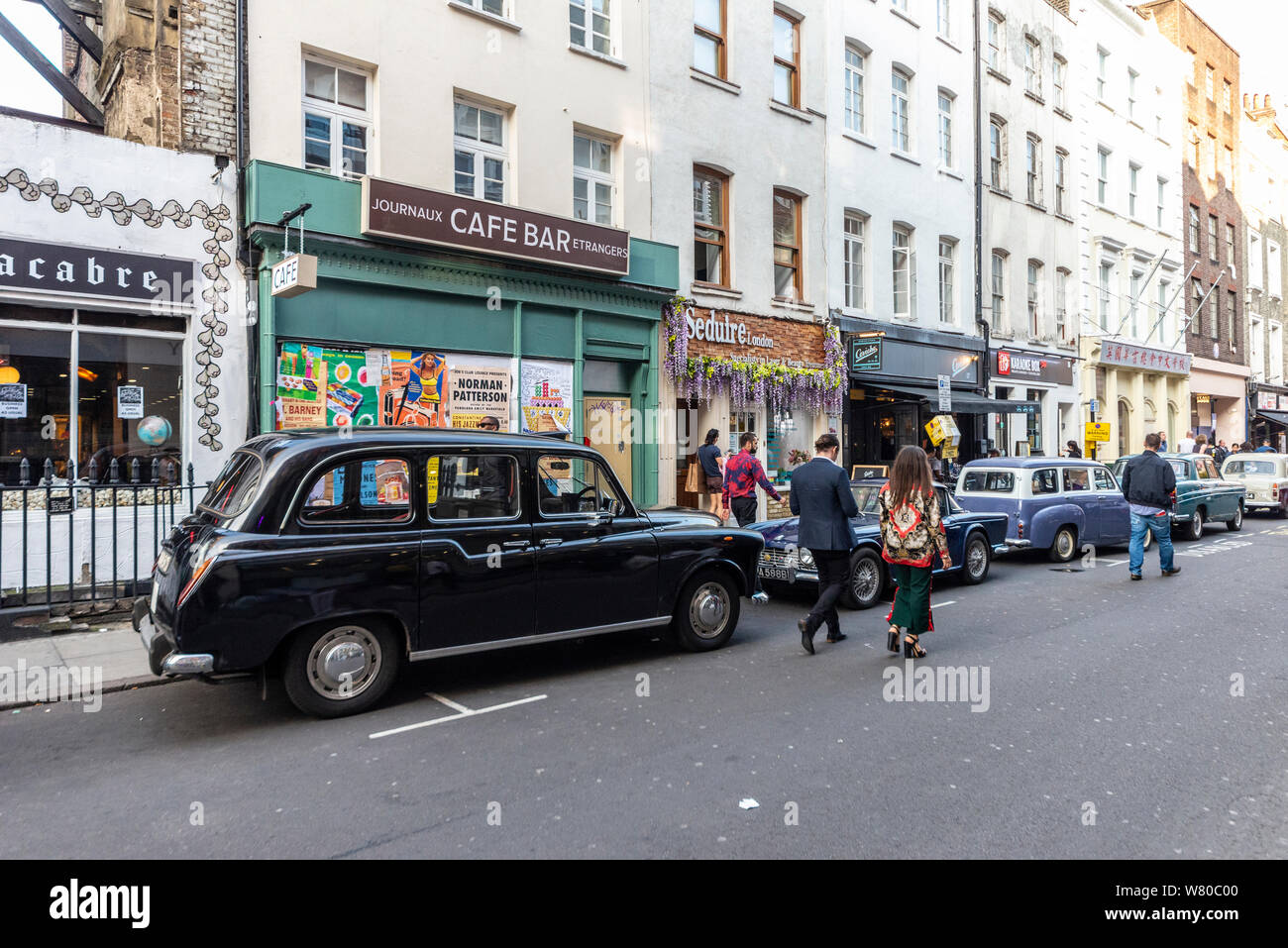 Street en el Soho, Londres, vestidos para la última noche en Soho, la  próxima película de terror psicológico dirigida por Edgar Wright.  Escaparates y coches antiguos Fotografía de stock - Alamy