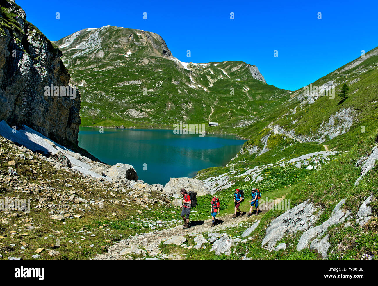 Los excursionistas en el lago de montaña Iffigsee, Lenk, Suiza Foto de stock