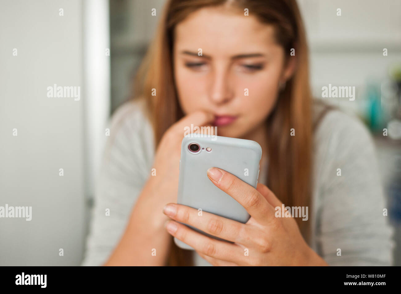 Una morena joven mirar la pantalla de su smartphone Foto de stock
