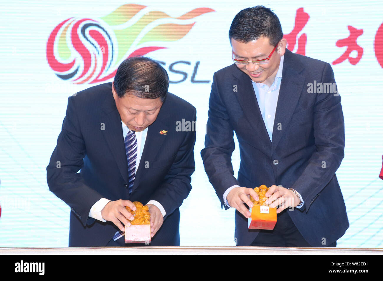 Ma Chengquan, izquierda, presidente de la Chinese Super League (CSL), Zan Kuang Zhanyu, derecha, CEO de Imaginechina, sellos sellos durante una ceremonia de firma a Ann Foto de stock