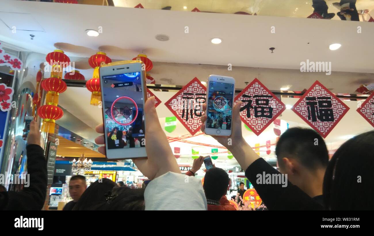 Los chinos utilizan sus smartphones para escanear los caracteres chinos "Fu", que significa "Suerte" en inglés, para reproducir un Pokemon Go-inspiró la realidad aumentada g Foto de stock