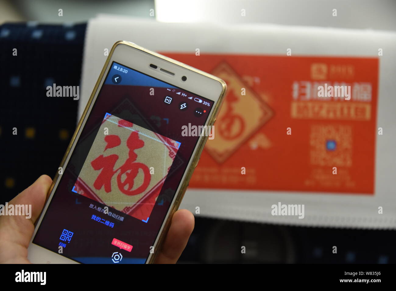 Un pasajero chino utiliza su smartphone para escanear el carácter chino "Fu", que significa "Suerte" en inglés, para reproducir un Pokemon Go-inspiró la realidad aumentada Foto de stock