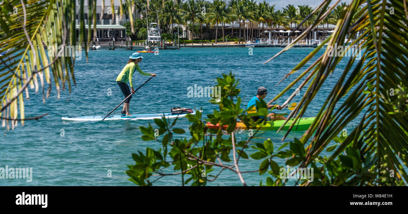 Stand-up paddleboarder y kayakistas en la joya de agua azul de la entrada de Júpiter en la marea entrante en Júpiter, el condado de Palm Beach, Florida. (Ee.Uu.) Foto de stock