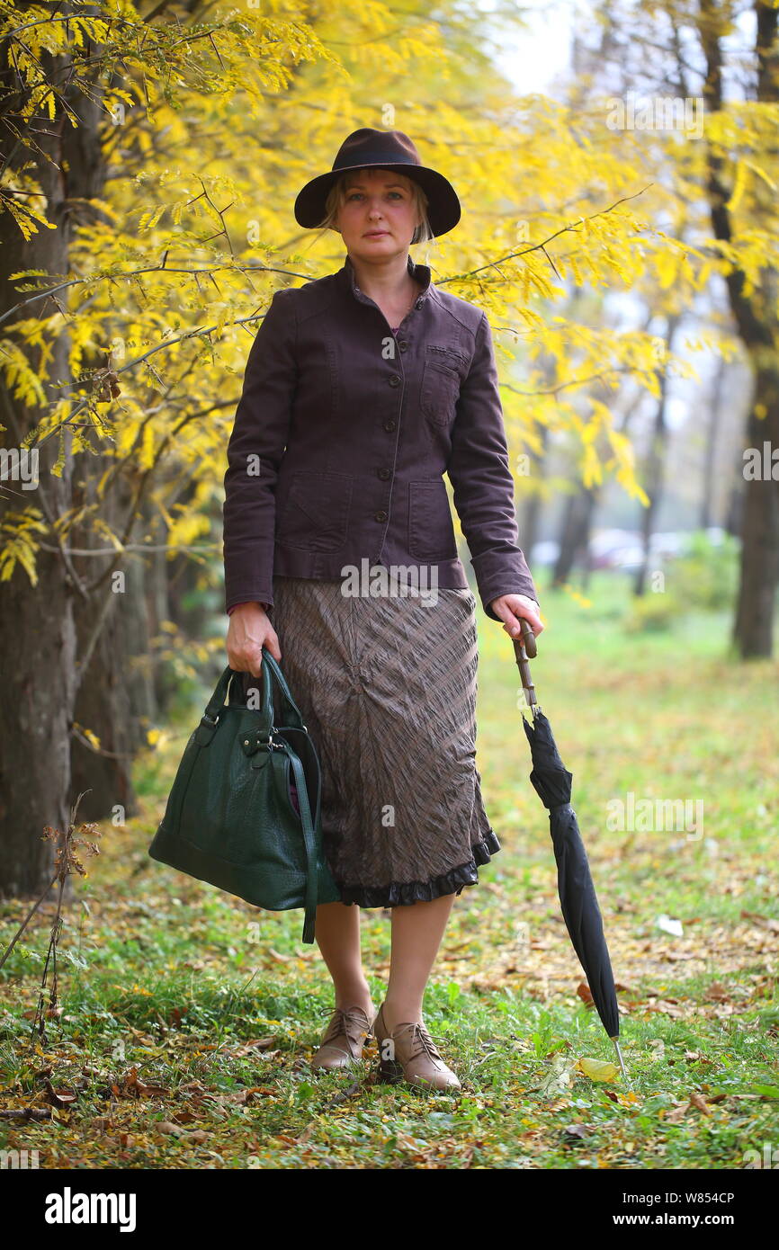 Chica en traje de Mary Poppins en otoño del parque con un paraguas y bolsa  Fotografía de stock - Alamy
