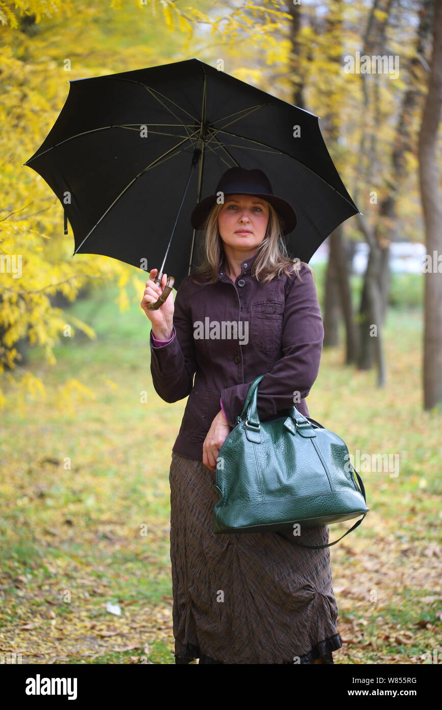 presupuesto Desnudo Ese Chica en traje de Mary Poppins en otoño del parque con un paraguas y bolsa  Fotografía de stock - Alamy