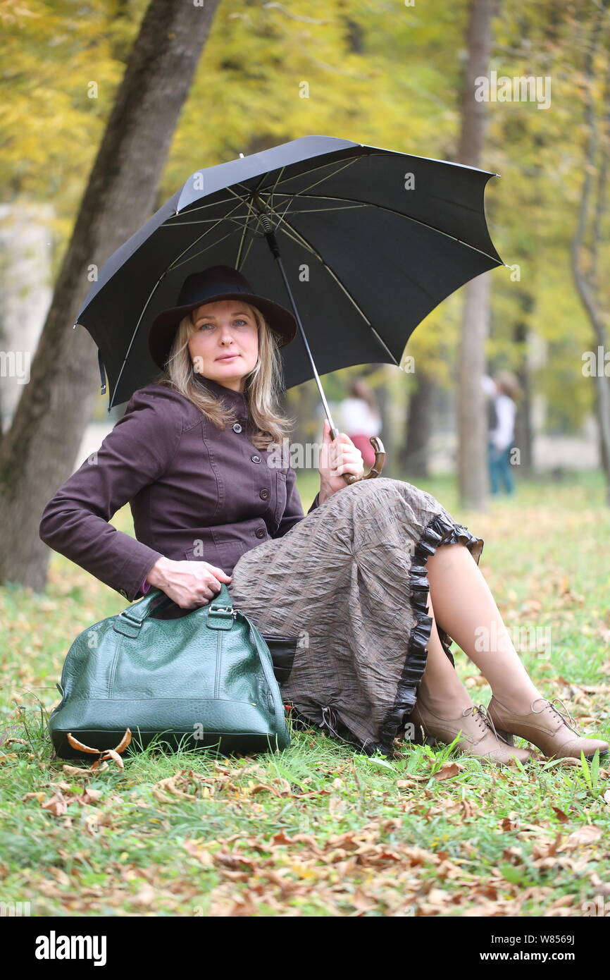 Chica traje de Mary Poppins en otoño del parque con un paraguas y bolsa Fotografía de stock Alamy