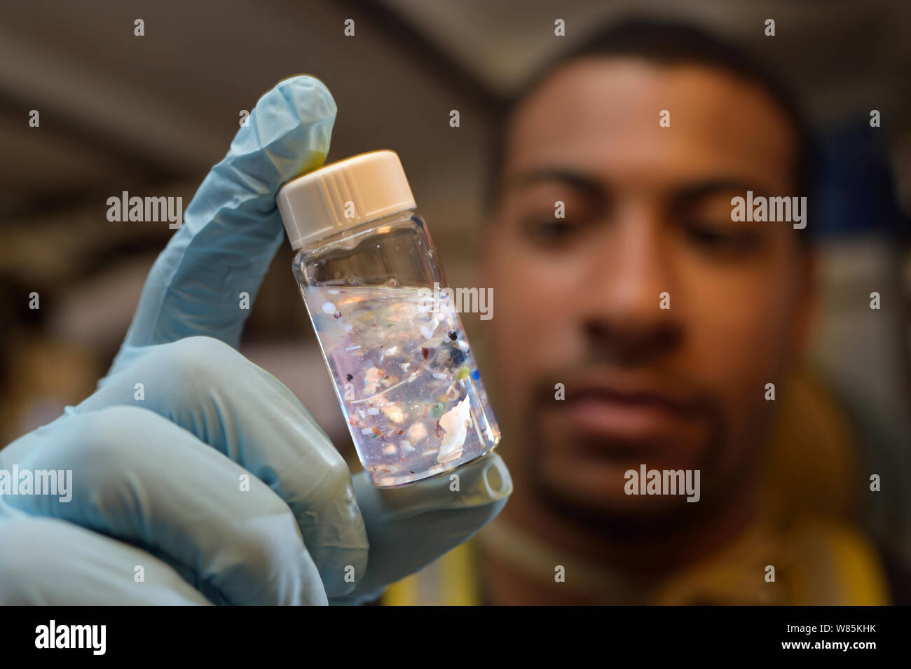 Estudiante con vial pf micro plásticos procedentes de muestras marinas, en el laboratorio de la Tall Ship Corwith Cramer. Mar de los Sargazos, Bermuda. De abril de 2014. Foto de stock