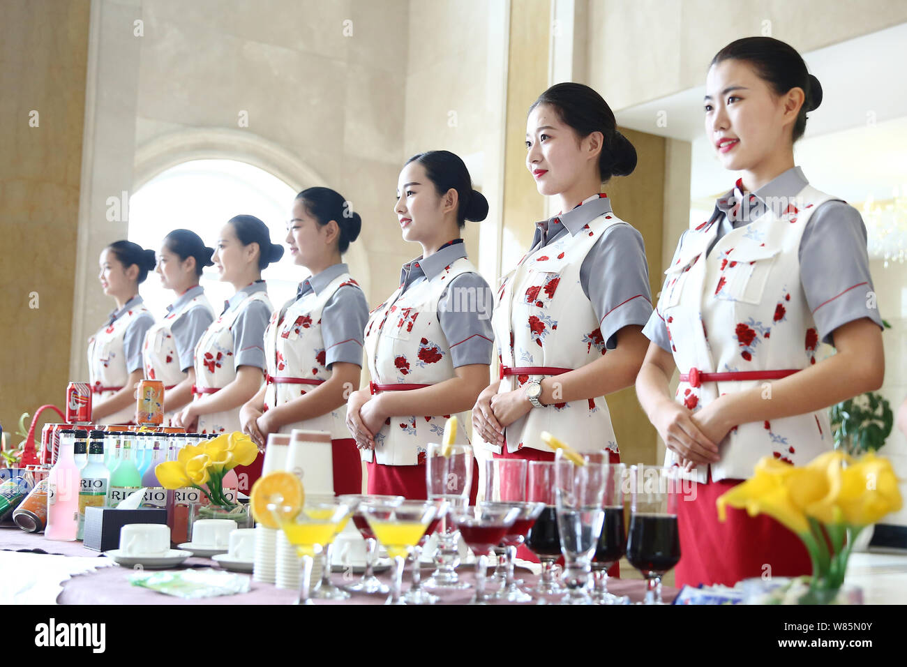 Los estudiantes universitarios vestidos con uniformes de azafatas de pie en  una fila para dar la bienvenida a los estudiantes de primer año y sus  padres en el suroeste de Sichuan de