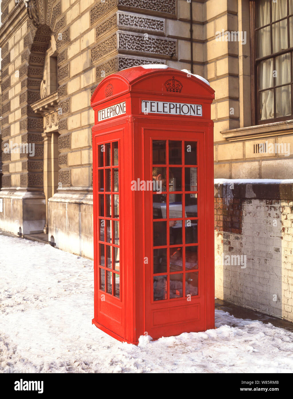 Teléfono rojo tradicional kiosco en invierno, la nieve, la Plaza del Parlamento, la ciudad de Westminster, Greater London, England, Reino Unido Foto de stock