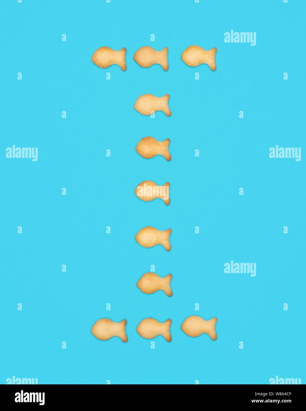 I mayúscula del alfabeto latino de galletas en forma de peces sobre un fondo azul. Foto de stock