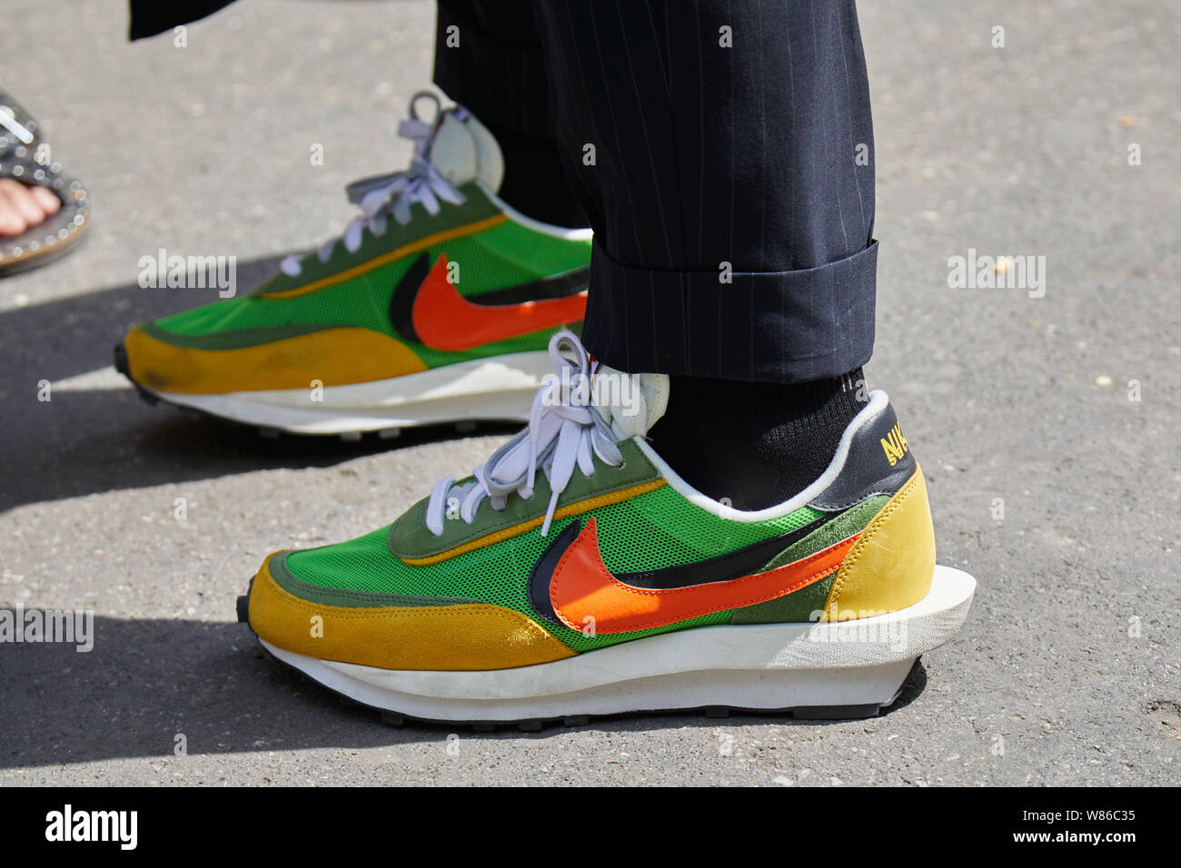 Milán, Italia - Junio 15, 2019: hombre con verde, naranja y amarillo zapatillas