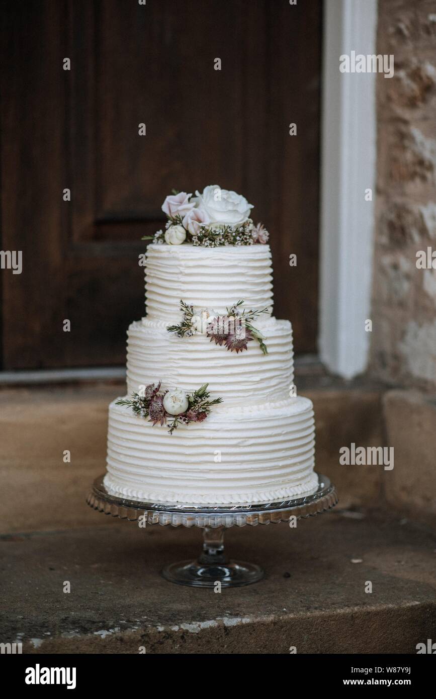 Tiro vertical de una torta de boda de tres capas decorada con 