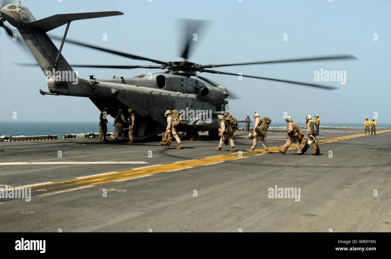 Los Marines de Estados Unidos se preparan para abordar un tipo CH-53E Super Stallion helicóptero asignado a Helicópteros Marinos mediano 165 Escuadrón a bordo del USS Peleliu (LHA 5) en el Mar Arábigo para apoyar a aquellos que proporcionan suministros de socorro a las zonas inundadas de Pakistán el 12 de agosto del 2010. Foto de stock