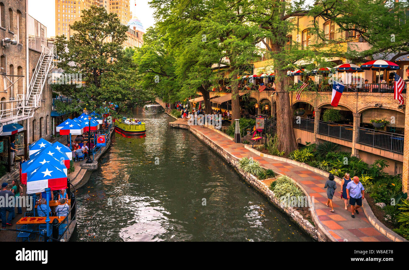 San Antonio River Walk en horario diurno con turistas sentados en los patios y en ruta. Foto de stock
