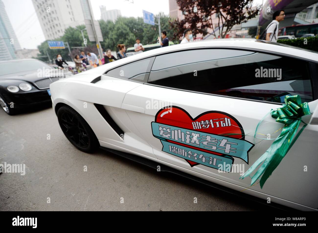 Lamborghini Gallardo y Bentley Flying Spur autos de lujo llegan a la Escuela Secundaria Experimental Shandong como parte de un desfile de automóviles de lujo voluntariamente a Foto de stock
