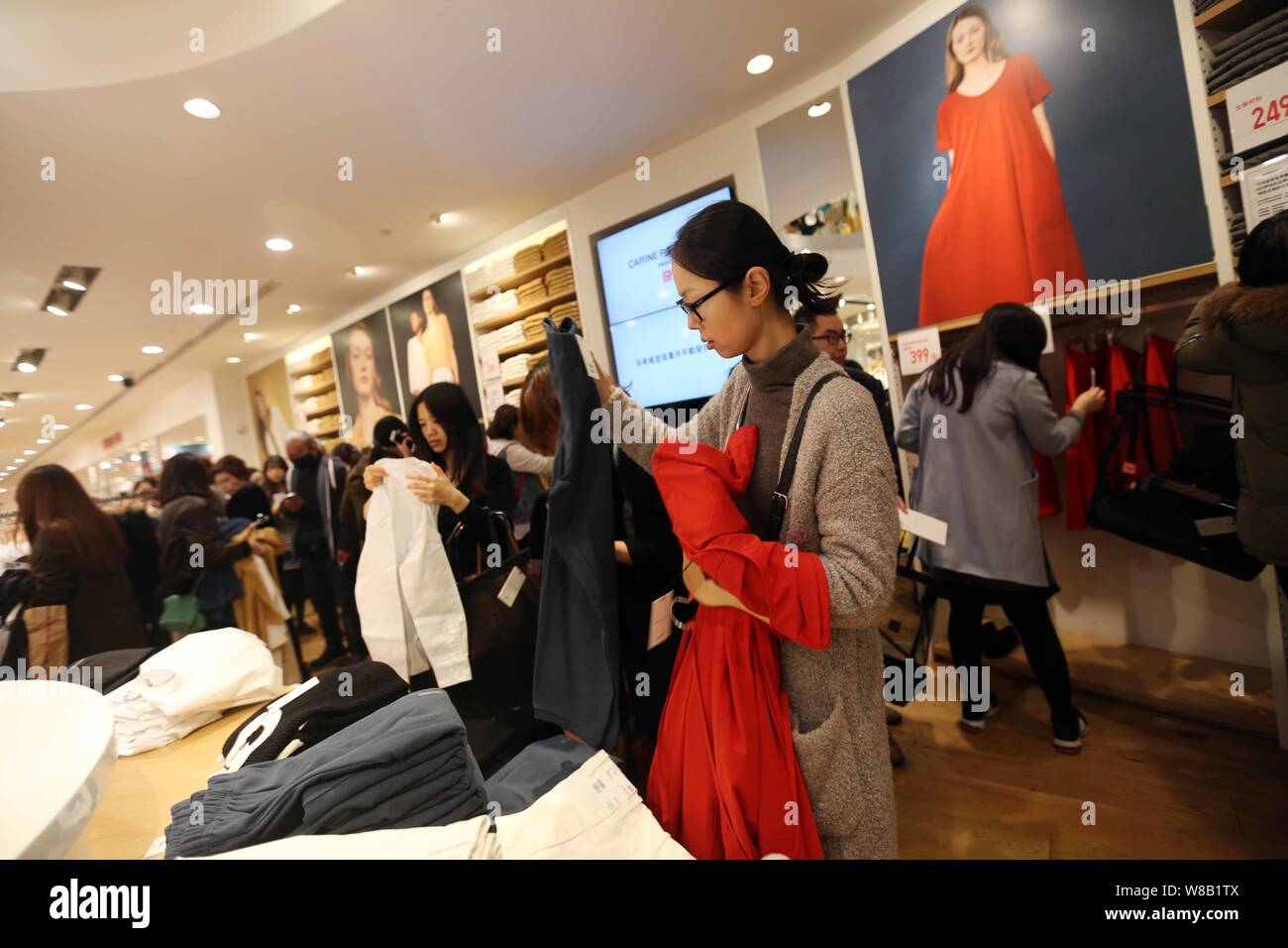 FILE--chino clientes comprar ropa en una tienda de moda de Uniqlo en  Shanghai, China, 4 de marzo de 2016. Cadena de ropa japonesa Uniqlo ha  leverag Fotografía de stock - Alamy