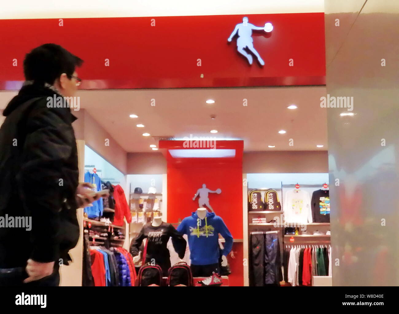 FILE -- un cliente camina más allá de un almacén de ropa deportiva Qiaodan  Sports en un centro comercial de Shanghai, China, 9 de marzo de 2012. Una  demanda interpuesta por marca