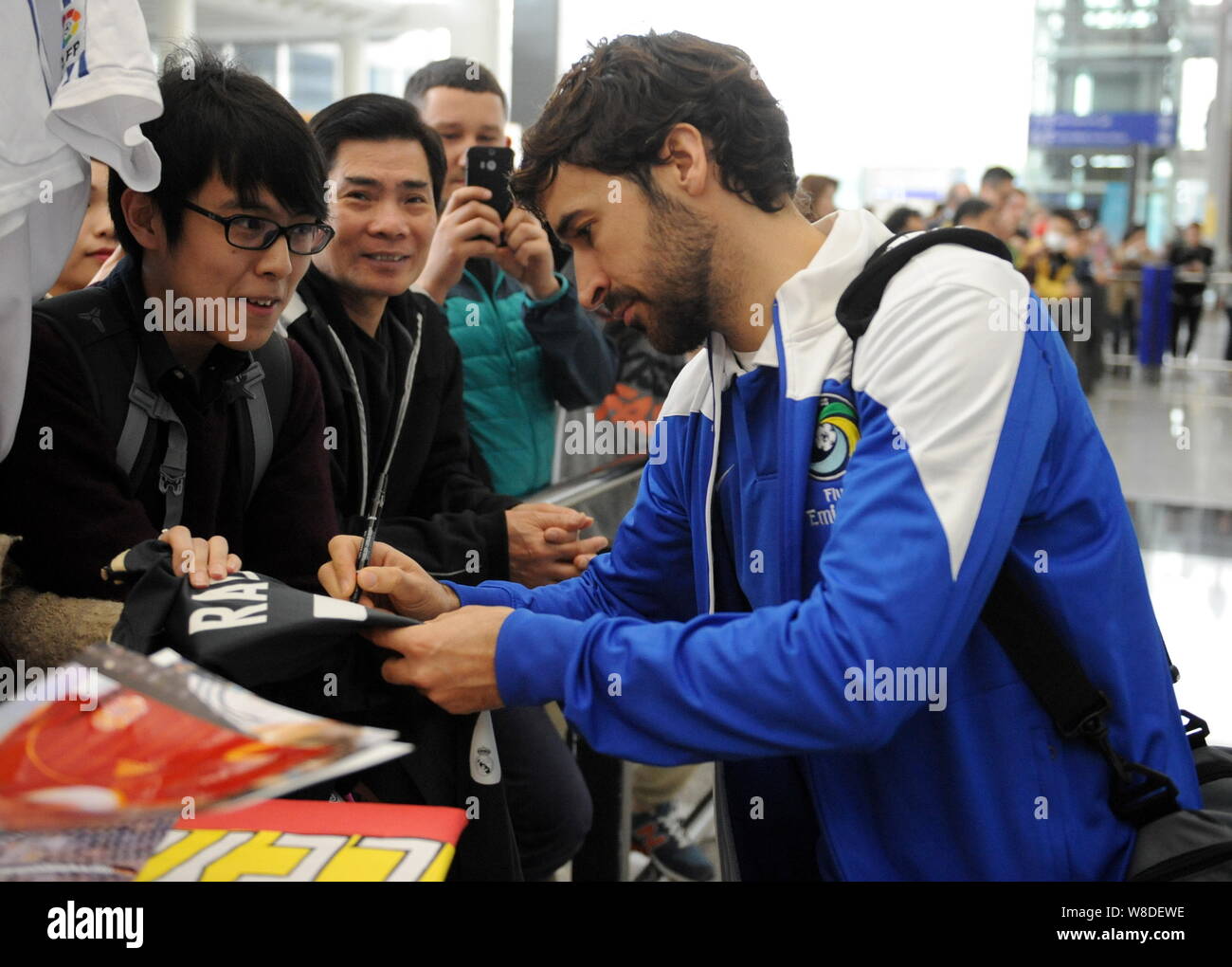Futbolista español Raúl González Blanco del Cosmos de Nueva York, a la derecha, firma autógrafos para los fans como él llega al Aeropuerto Internacional de Hong Kong i Foto de stock
