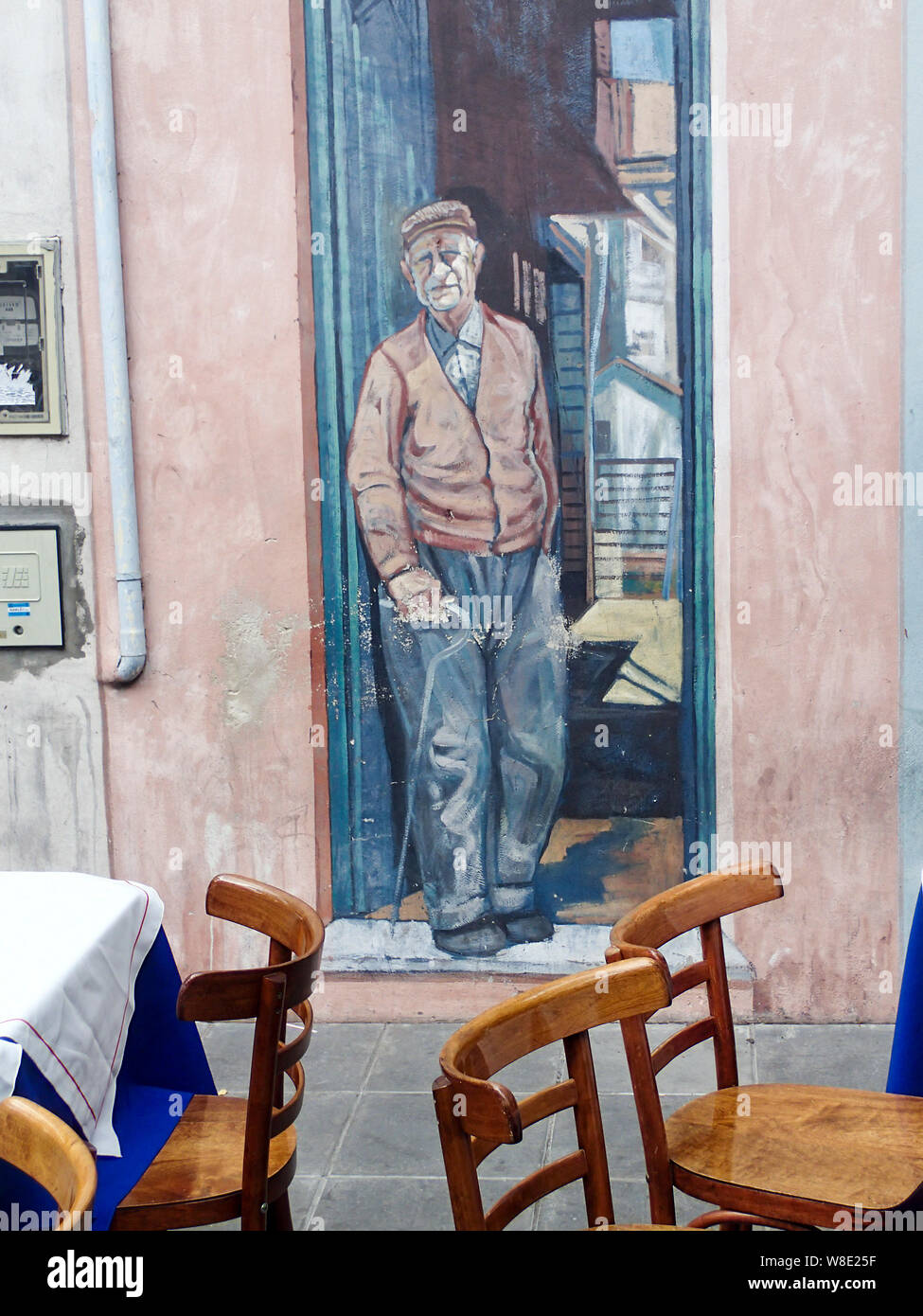 Buenos Aires, Argentina - Marzo 4, 2013: los murales en Buenos Aires con restaurante sillas en primer plano Foto de stock