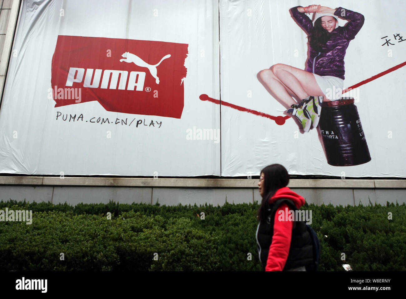 asistente metálico Oblea FILE--un peatón camina pasado un anuncio de la marca de ropa deportiva  alemana Puma en Shanghai, China, 28 de febrero de 2014. Lujo y sportswear  group Fotografía de stock - Alamy
