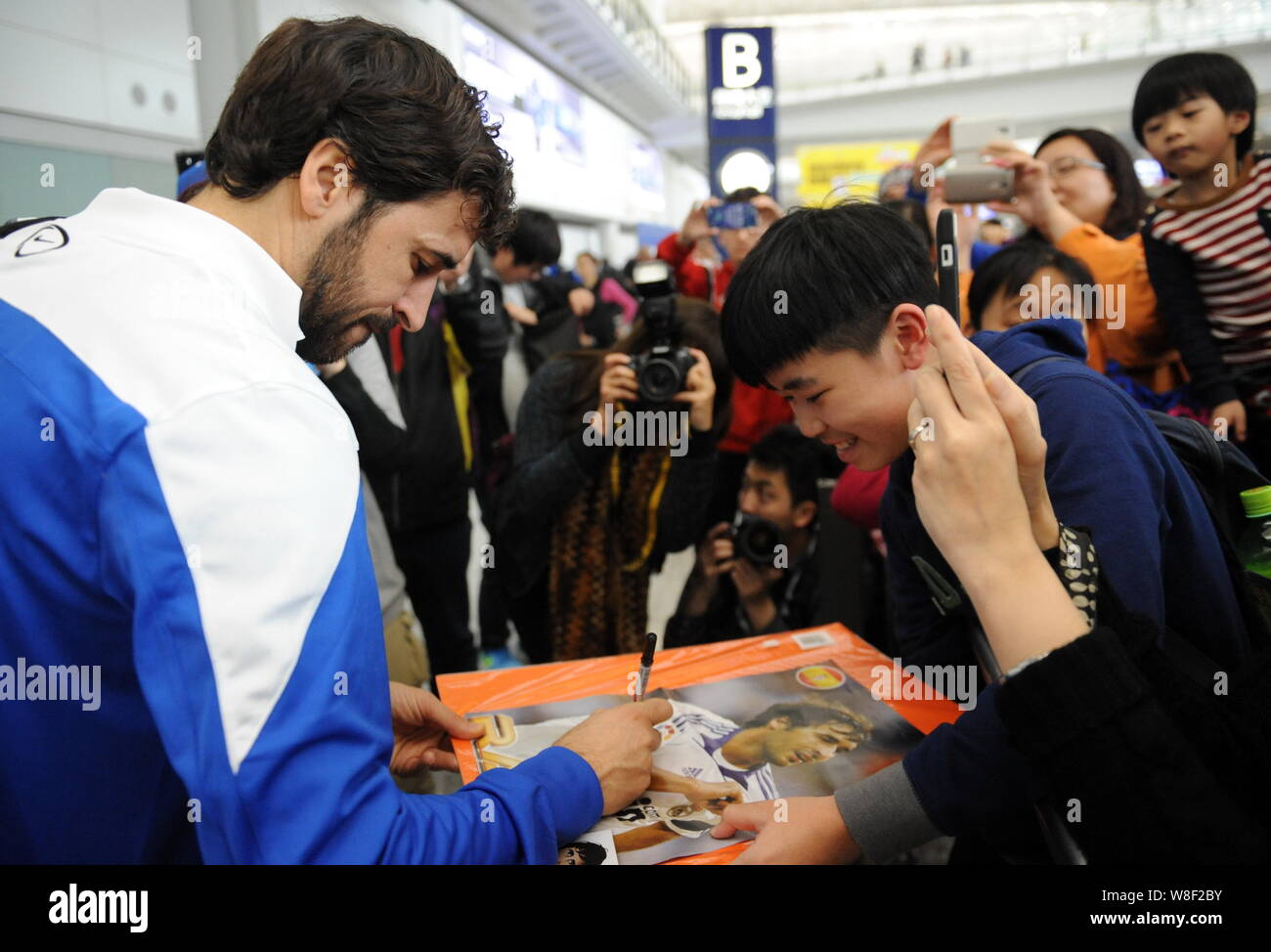 Futbolista español Raúl González Blanco del Cosmos de Nueva York, izquierda, firma autógrafos para los fans como él llega al Aeropuerto Internacional de Hong Kong en Foto de stock