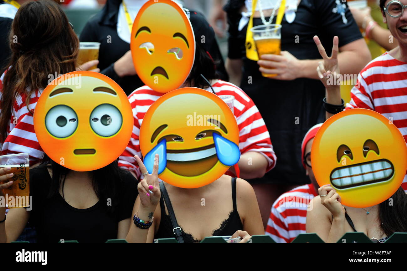 Fans portando máscaras emoji ver un partido de Rugby Seven de Hong Kong de 2015 en Hong Kong, China, 28 de marzo de 2015. En el Hong Kong Rugby Sevens 120.000 p Foto de stock